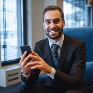 Handsome,Young,Businessman,Wearing,Suit,Sitting,At,The,Hotel,Lobby,